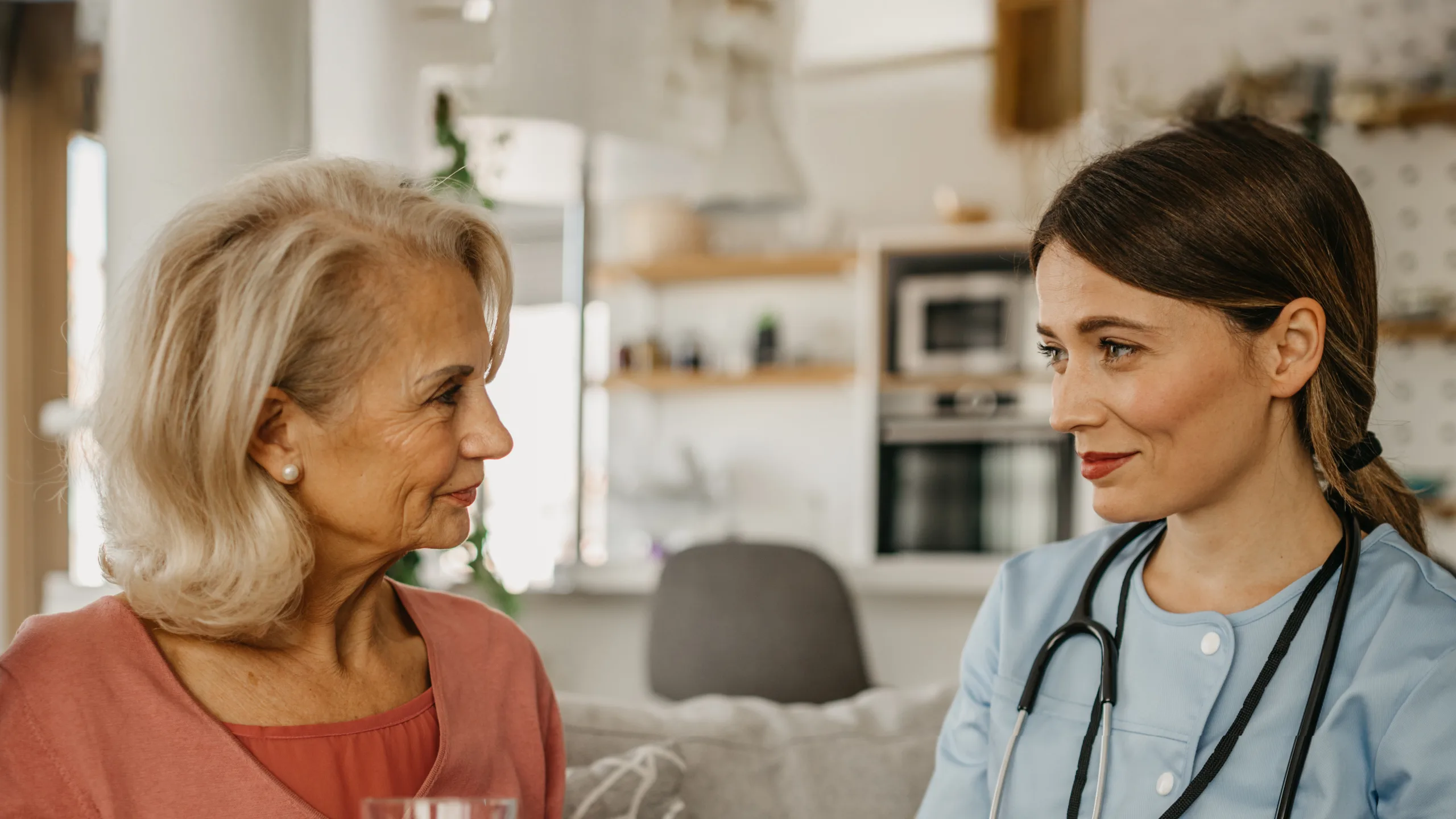 Nurse sitting with female resident in care home